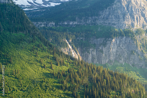 View of Bird Woman Falls, Clements Mountain, and Mount Cannon at sunset and golden hour from the Going to the Sun Road in Glacier National Park in Montana on a summer day