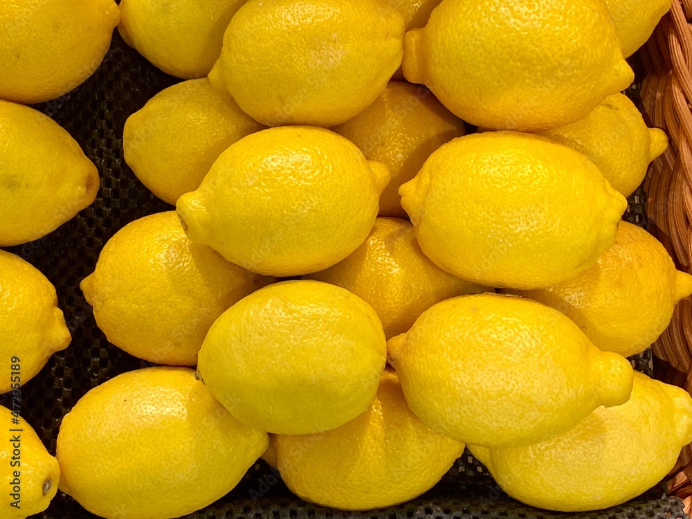 Close-up photo of lemons in market. Fruits background. Texture yellow lemon. 