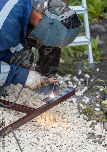 A worker welds metal at a construction site.