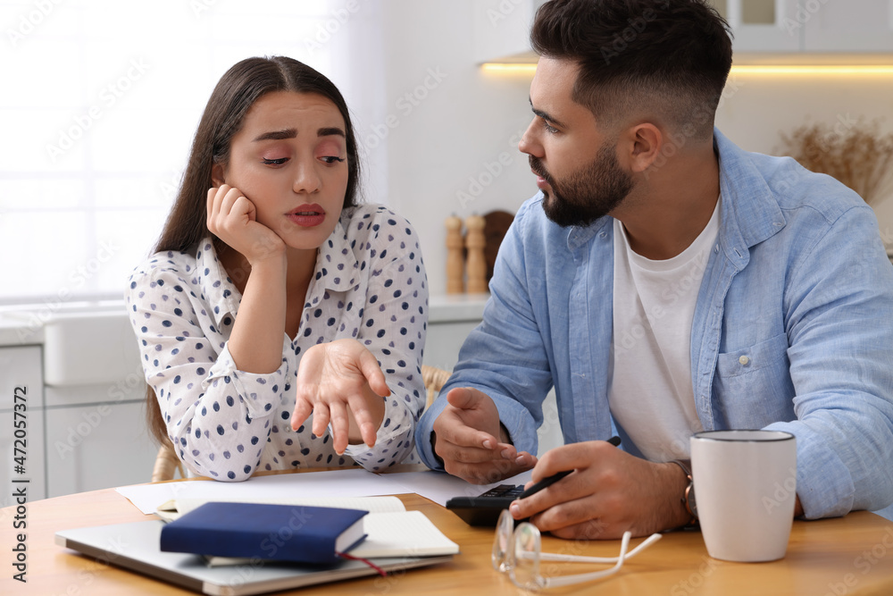 Young couple discussing family budget in kitchen Young couple discussing family budget in kitchen