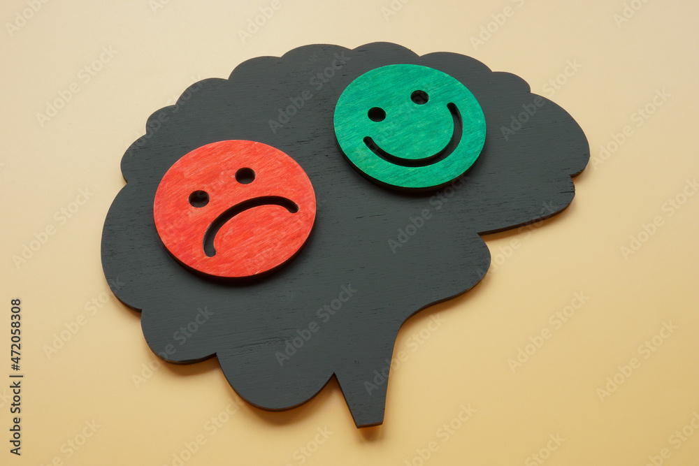 Bipolar disorder concept. Brain shape with happy and sad emoticons. - obrazy, fototapety, plakaty 