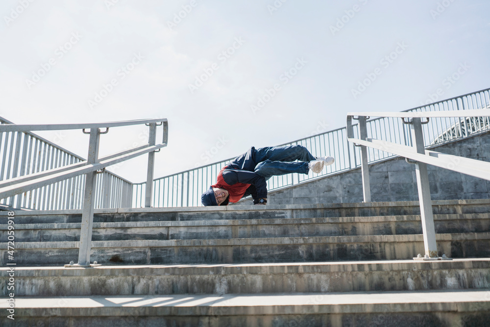 Naklejka premium young trendy culture, male person hip hop pose outdoors in the street