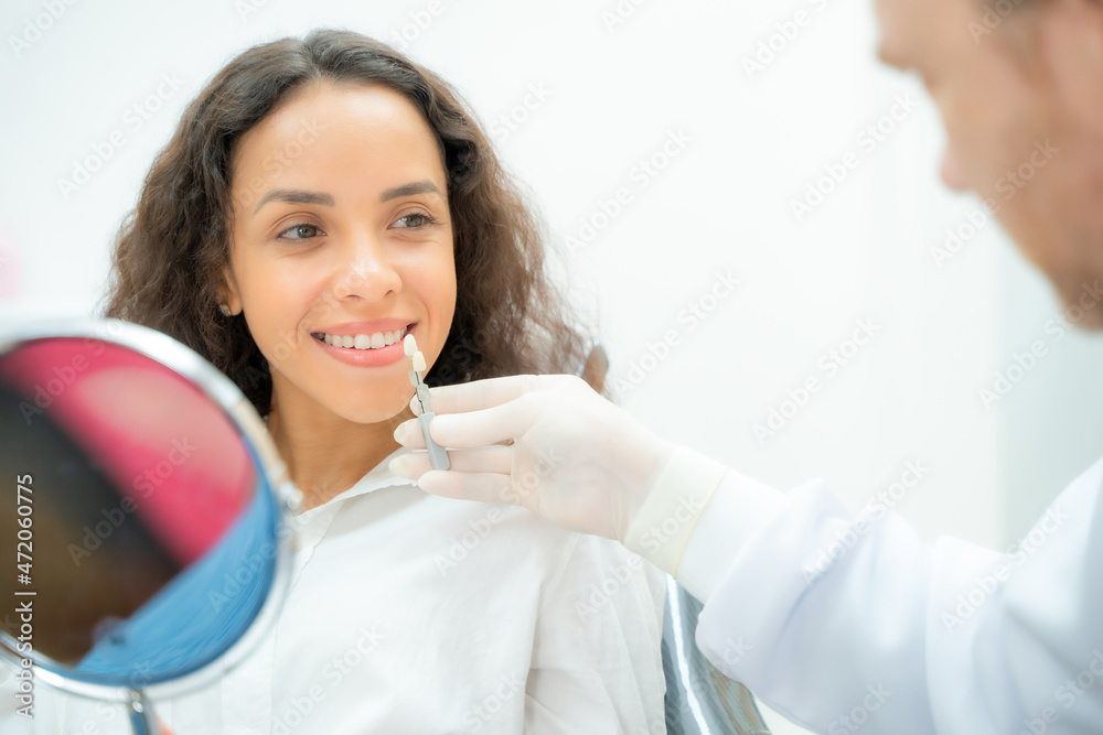 Dentist checking and selecting color of young women,Compare teeth with sampler in dentistry. Dentist checking and selecting color of young women,Compare teeth with sampler in dentistry.