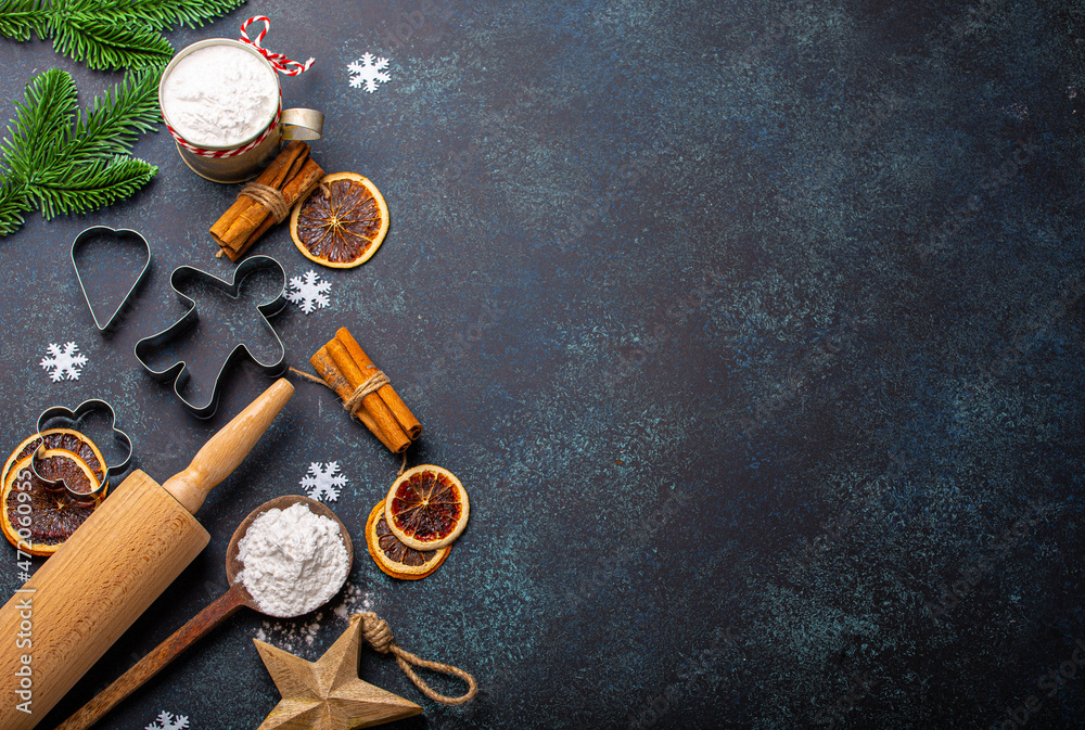 Christmas and New Year festive baking background with kitchen tools, flour, fir tree branch, metal cookie cutters on dark blue stone concrete background table top view, space for text frame Christmas and New Year festive baking background with kitchen tools, flour, fir tree branch, metal cookie cutters on dark blue stone concrete background table top view, space for text frame