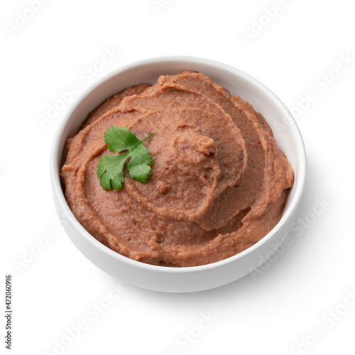 Bowl with brown refried beans paste close up isolated on white background