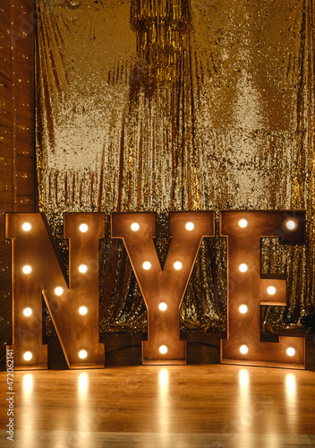 Loft idea for Christmas. Bulb lights on wooden stand letters NYE. photo