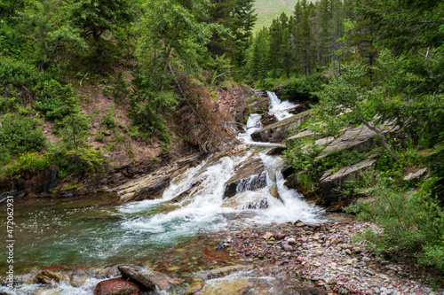 View of Wilbur Creek Falls at Swiftcurrent and Many Glacier in Glacier National Park in Montana in the summer © Sitting Bear Media