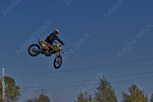 Kyiv  Ukraine - Extreme jump on a motorcycle against a background of blue sky. Active extreme rest. High flying motorcycle racer.