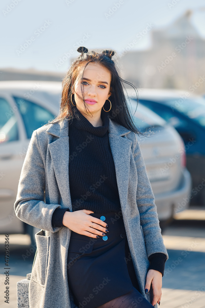 Obraz premium Young woman posing at the parking near the mall