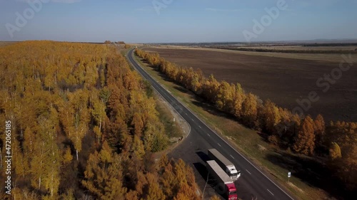 Autumn highway in the central part of Russia. Truckers' parking lot. Top view of 4k video. Yellow birch crowns and an endless road