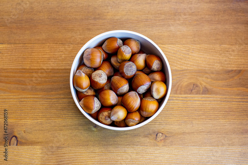 Hazelnuts in the bowl on wooden table
