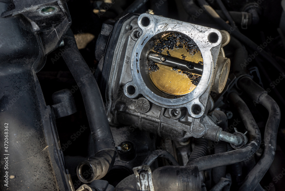 The throttle valve on the engine of a car with contamination due to