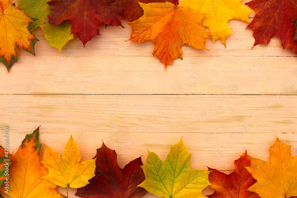 Autumn background. On a wooden board lie yellow leaves at the edges. Autumn background. On a wooden board lie yellow leaves at the edges.