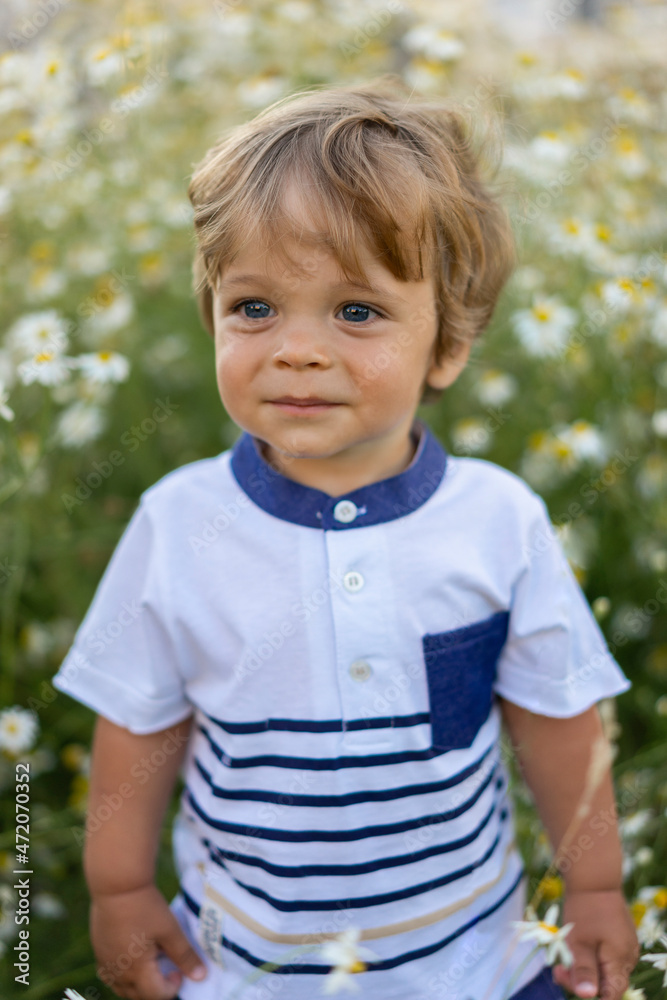 Cute blond boy standing in meadow Cute blond boy standing in meadow