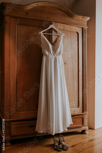 white wedding dress on wooden closet