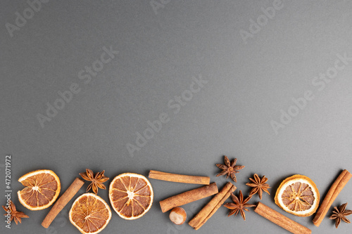 dried orange, cinnamon sticks, star anise and walnut on a gray background, the basis for a Christmas and New Year greeting card with copy space