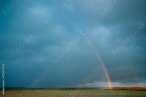 Rainbow In Countryside Rural Field Meadow Landscape. Agricultural Landscape. Weather Forecast Concept photo