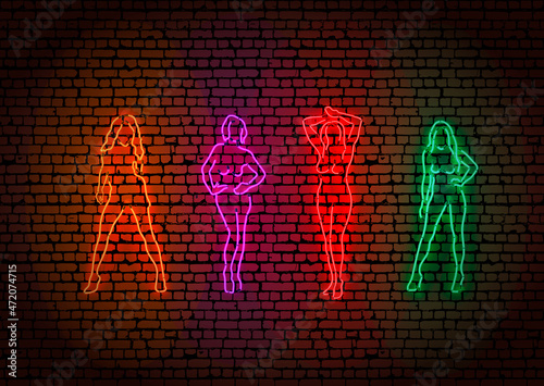 Colorful neon pipes in strip dancing girls shape on dark brick wall