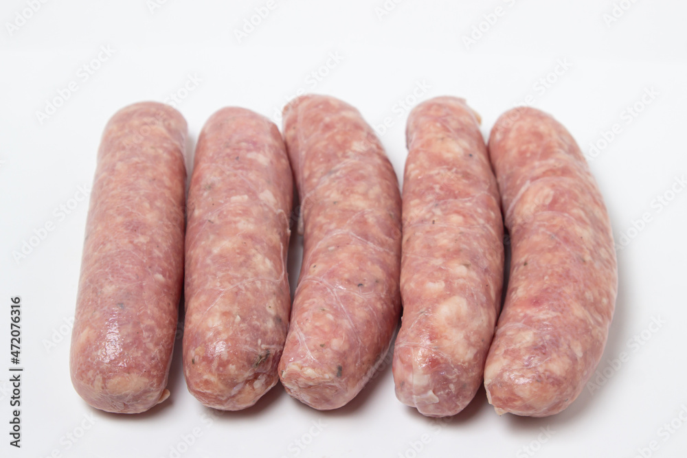 Raw meat sausages on a white plate. Homemade sausages in a natural casing. Meat products Raw meat sausages on a white plate. Homemade sausages in a natural casing. Meat products