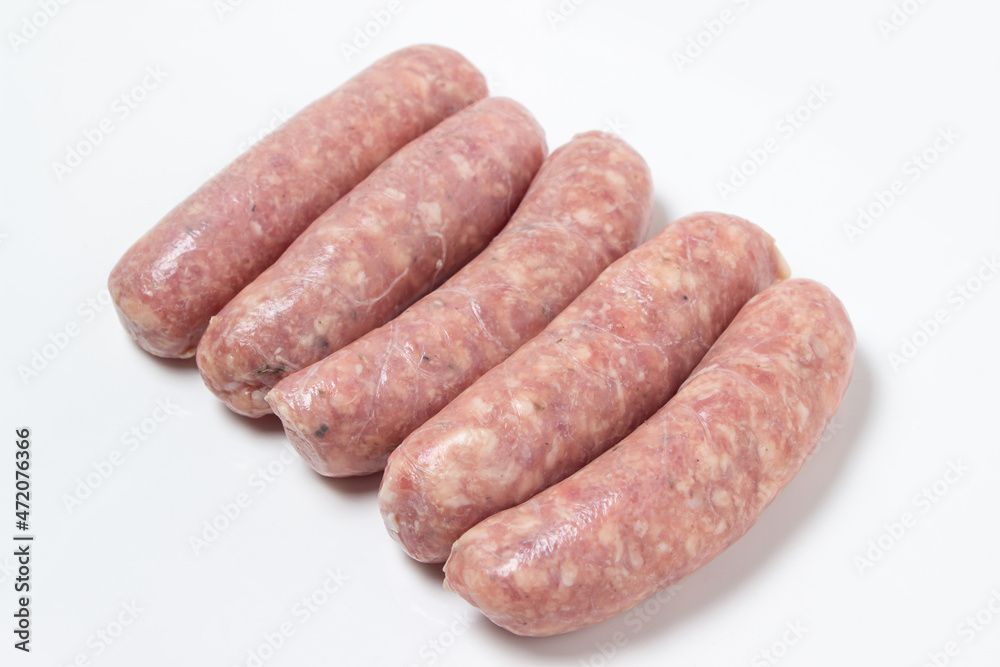 Raw meat sausages on a white plate. Homemade sausages in a natural casing. Meat products Raw meat sausages on a white plate. Homemade sausages in a natural casing. Meat products