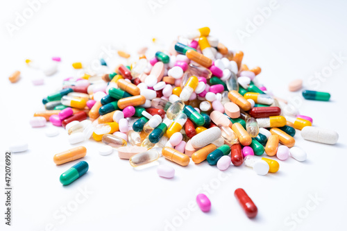 Pile of drugs with a variety of colorful tablets, pills, capsules and dragees on white background. Health service, care, pharmacy, medical or pharmaceutical concept. 