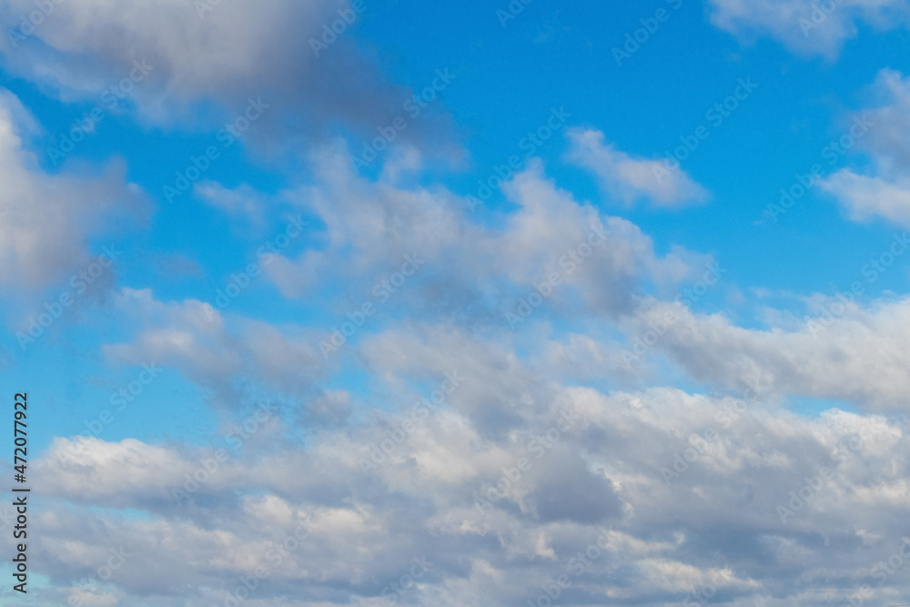White fluffy clouds in the blue sky in sunny weather