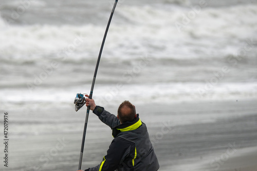 angler fisherman in surfcasting in beach