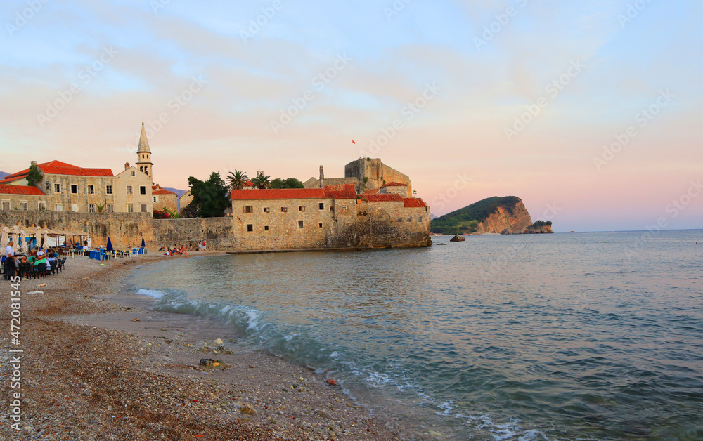 View of Budva Castle and old town beach at sunset in Montenegro