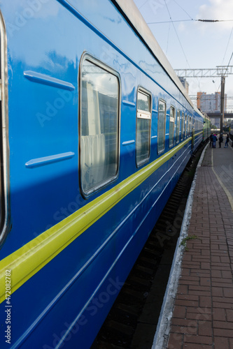 Odessa, Ukraine - 10|18|2020: A passenger train, a compartment carriage outside of a blue-and-blue color, stands on a pirone.
