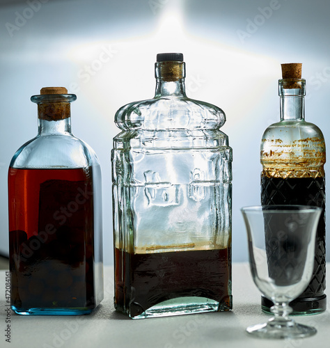 Alcoholic drinks. Several bottles of liquor and a glass. photo