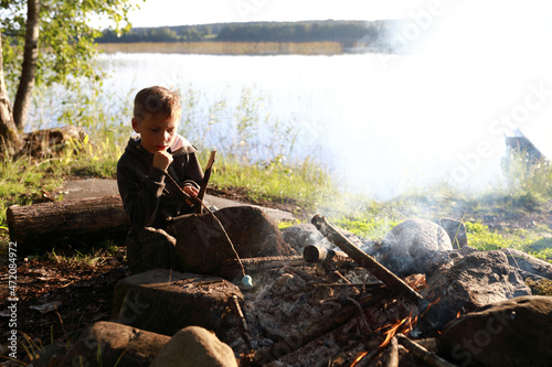 Child frying marshmallows over fire