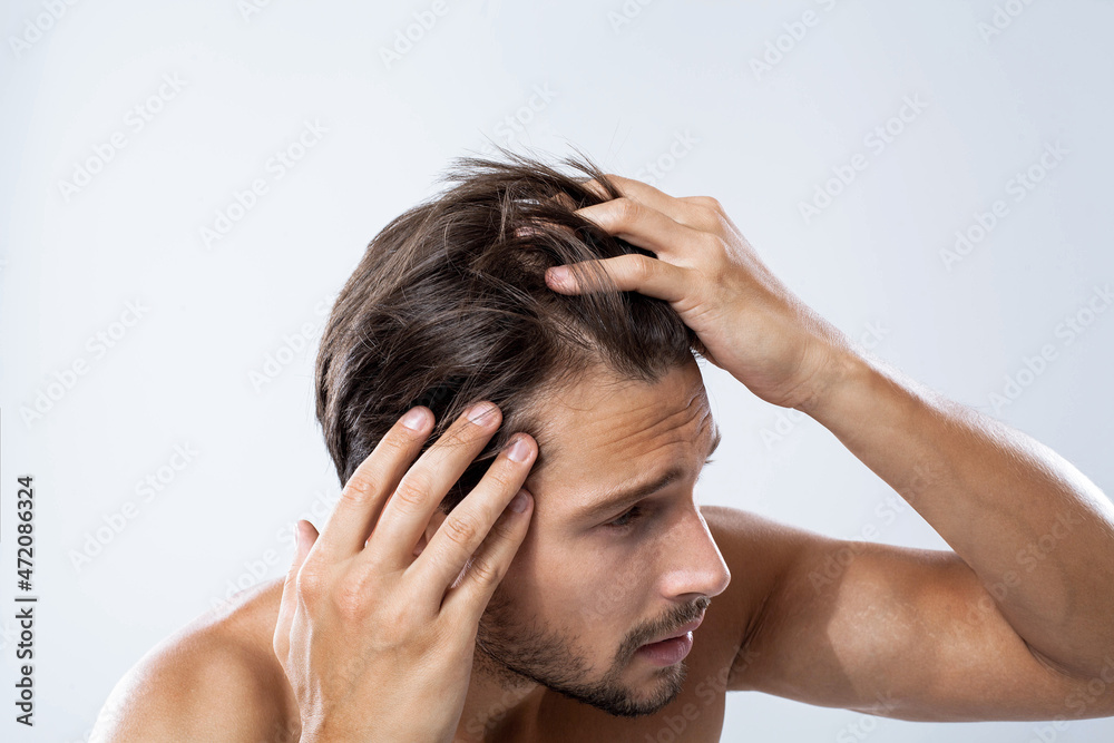 Fototapeta premium Frightened man looking at his receding hairline