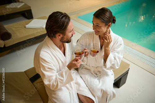 Quadro su tela Handsome Caucasian man and gorgeous woman, wearing white terry bathrobes, chilli