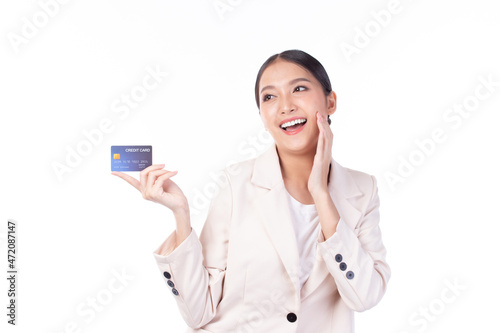 Portrait of a happy young asian woman wearing suit holding bank card, credit card isolated on white background. Business online shopping concept.