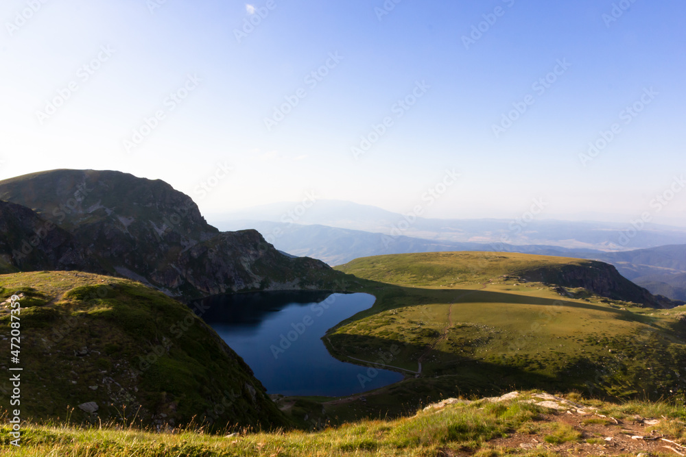 On the top of the mountains, landscape on green mountains and mountain lakes, above the clouds at sunset On the top of the mountains, landscape on green mountains and mountain lakes, above the clouds at sunset