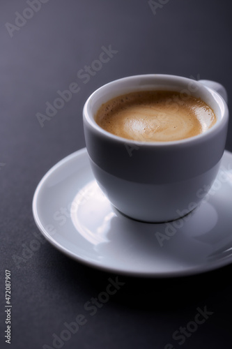 Cup of coffee on dark paper background. Close up.