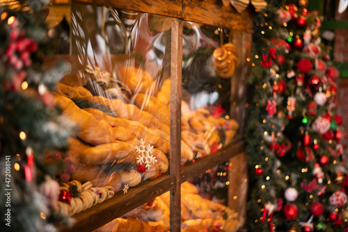 Old bakery window on christmas eve. Freshly baked bread and rolls are sold in bakery window. Showcase with traditional french pastries. Bread on showcase in supermarket