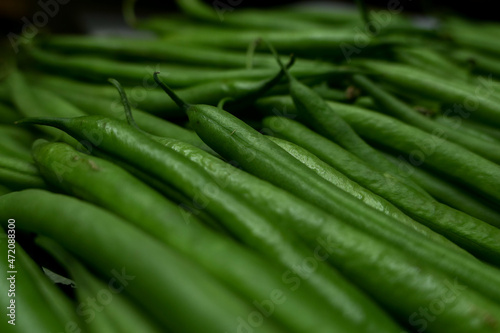 Close-up of fresh green beans lined up. Immature pods of common beans. Vegetable for vegetarian.