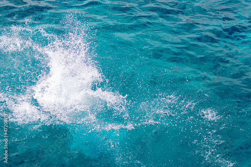 Splashes of blue, sea water with foam bubbles. A splash of nature on a summer day. blue sea background with splashing water. sea vacation concept.
