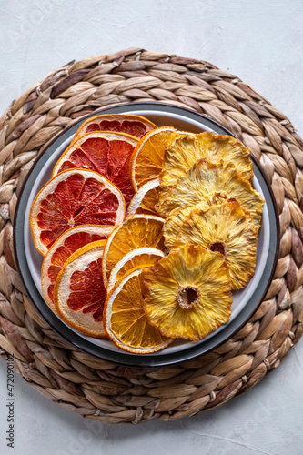 Homemade organic dried fruit slices. Dried orange  grapefruit  pineapples in a platel. Healthy snack or dessert.