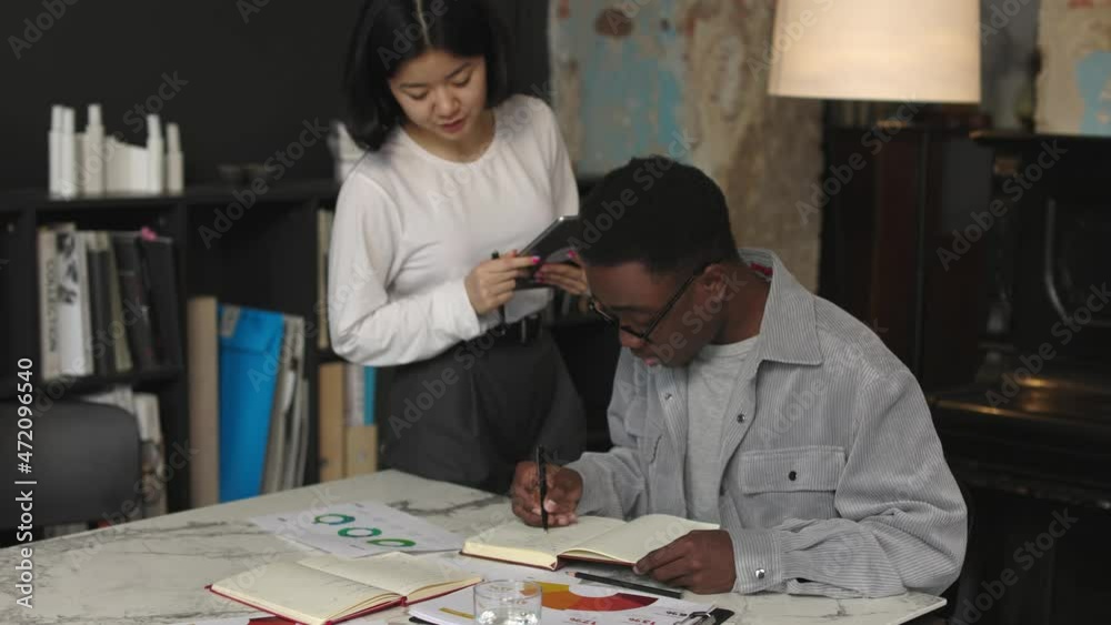 Two trendy diverse coworkers startup brainstorm of development internet project Two trendy diverse coworkers startup brainstorm of development internet project