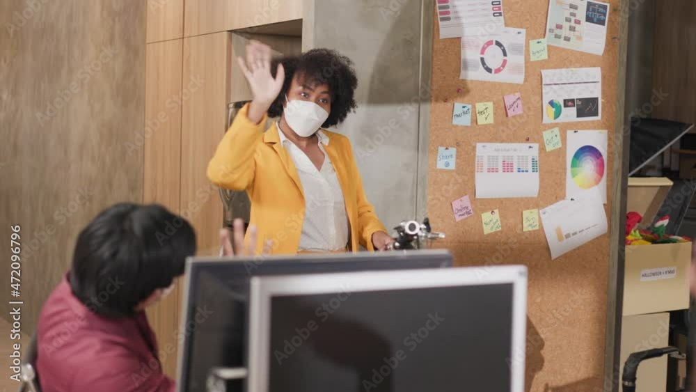 Young people with face masks back at work in office after lockdown.Asian small business startup meeting with laptop and chart paper everyone mask for covid19 protection corona. Young people with face masks back at work in office after lockdown.Asian small business startup meeting with laptop and chart paper everyone mask for covid19 protection corona.