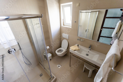Spacious bathroom in gray tones with heated floors  walk-in shower  double sink vanity.