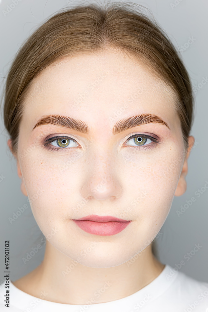 the face of the blonde model and the finished procedure lamination of eyebrows eyebrows combed with the help of long-term styling - obrazy, fototapety, plakaty 