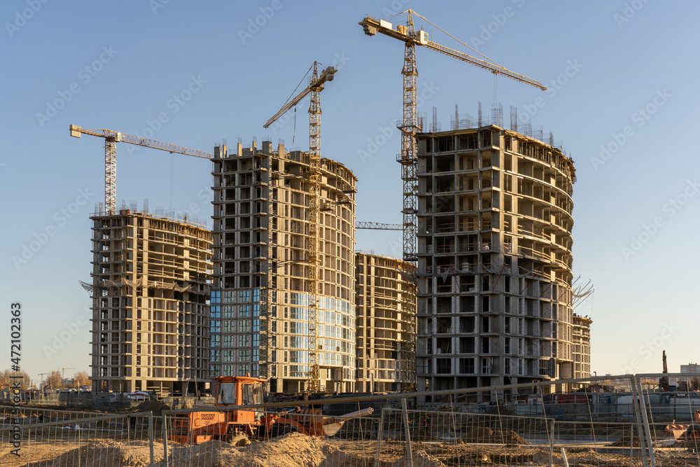 Photo of the construction site and building of high buildings and cranes against blue sky in the city. Constructional concept