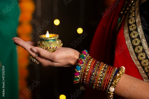 Woman hand's with bangles holding Diya  photo