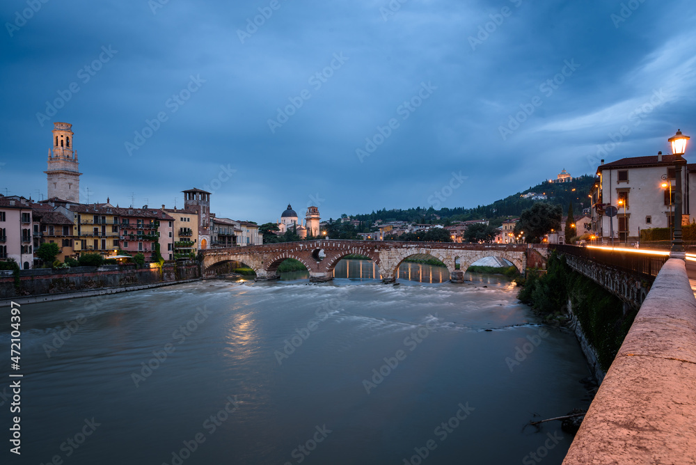 City landscape with the old town buildings along the bank of the Adige river and the famous Stone Bridge (Ponte di Piettra) at sunrise, Verona, Veneto Region, Italy