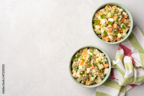 Traditional Russian salad Olivier in bowls on concrete background