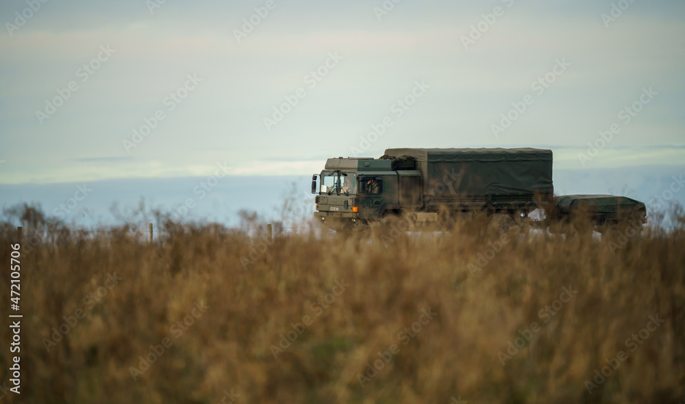 army logistics lorry vehicle truck with attached trailer driving along a dirt track in action on a military exercise, Salisbury Plain UK army logistics lorry vehicle truck with attached trailer driving along a dirt track in action on a military exercise, Salisbury Plain UK