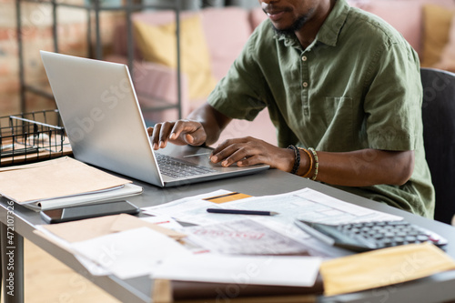 Fotografía Close-up of African American manager in green shirt sitting at table with papers